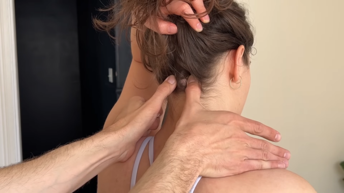 A Person Receiving a Neck Massage with A Focus on Pressure Points at The Base of The Skull, Using Targeted Finger Pressure for Relief