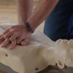 A Person Practicing Chest Compressions on A CPR Training Mannequin to Learn CPR