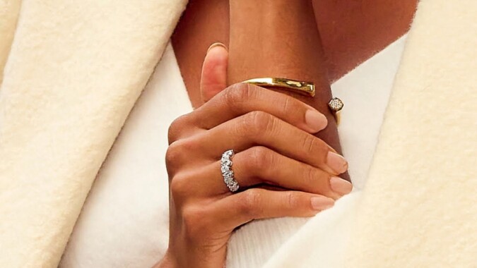 Close-Up of A Woman's Hand Wearing a Diamond Engagement Ring and Gold Bracelet